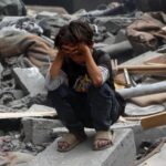 Aftermath of Israeli airstrike in Gaza City showing destroyed buildings and emergency responders.